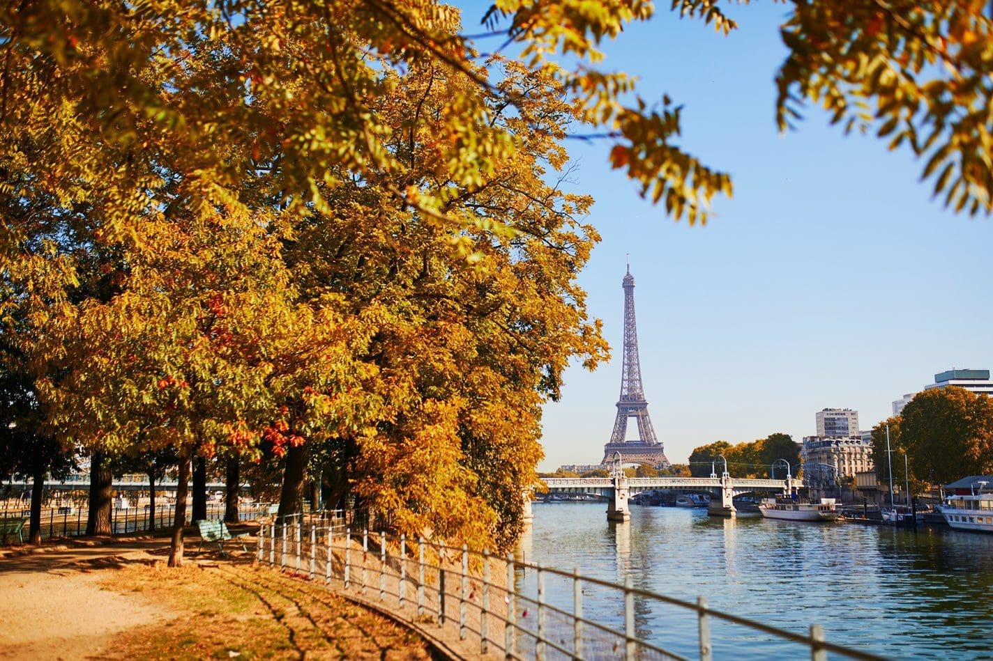 Autumn orange leaves in Paris with the Eiffel Tower in the background and the River Seine on the right hand side.